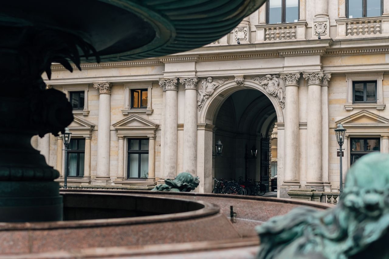Elegant architectural arches and details of Hamburg City Hall captured in an urban setting.